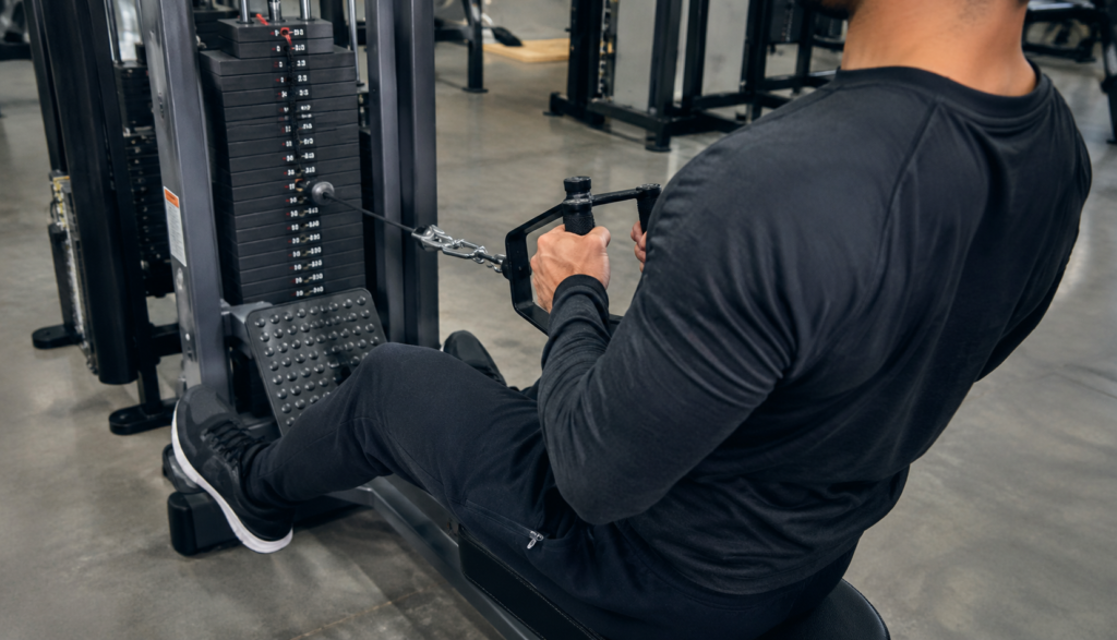 Person performing seated cable row with over-the-shoulder camera angle
