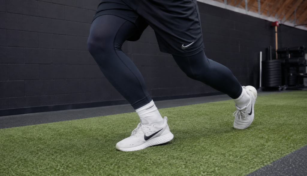 Close crop of feet during a lateral cutting movement on turf