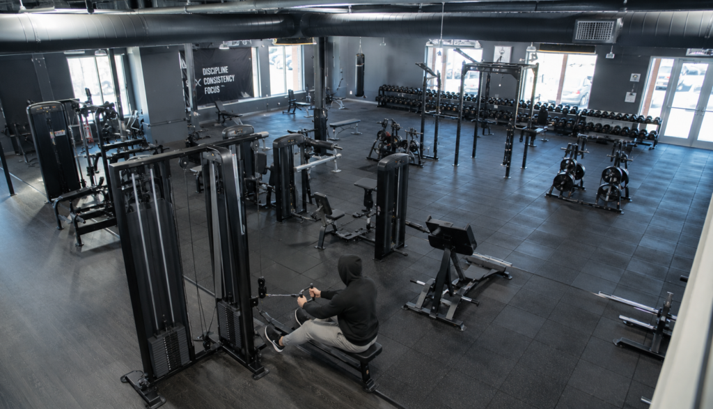 Wide gym shot of lifter performing a light seated cable row
