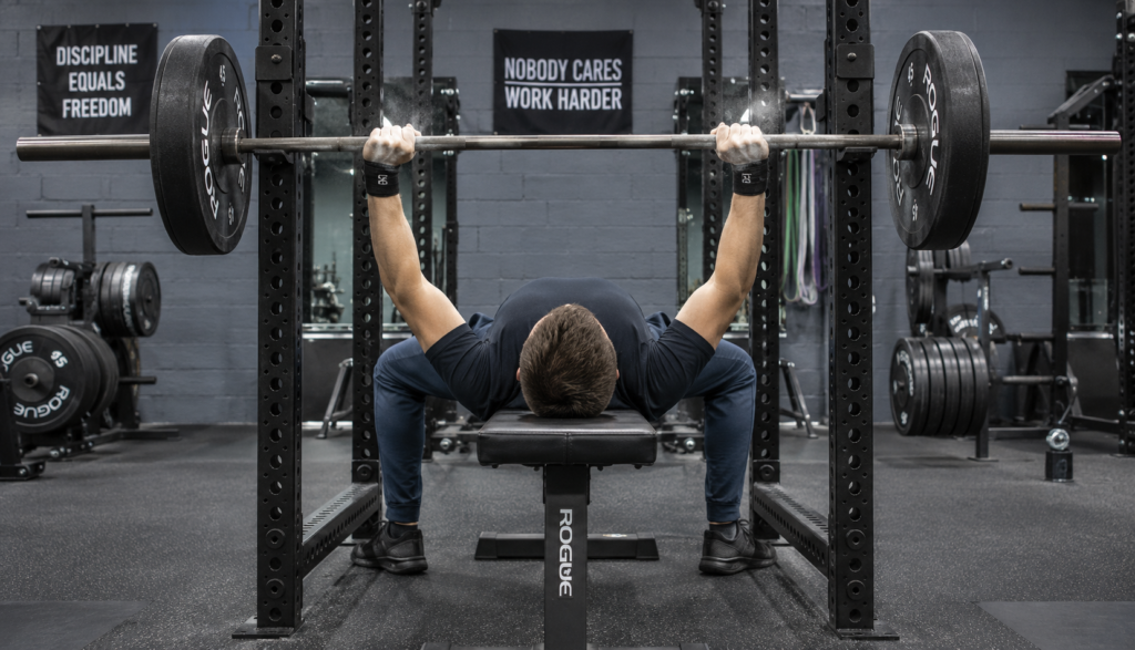 Lifter viewed from behind performing barbell bench press