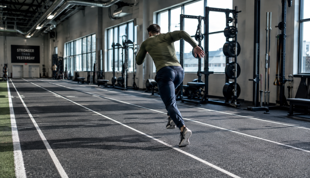 Athlete sprinting on indoor track during a VO2 max interval session
