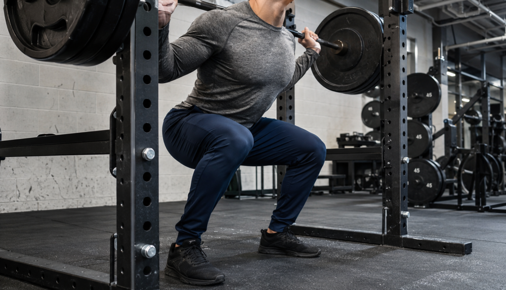 Lifter mid-squat descent viewed from a three-quarter front angle