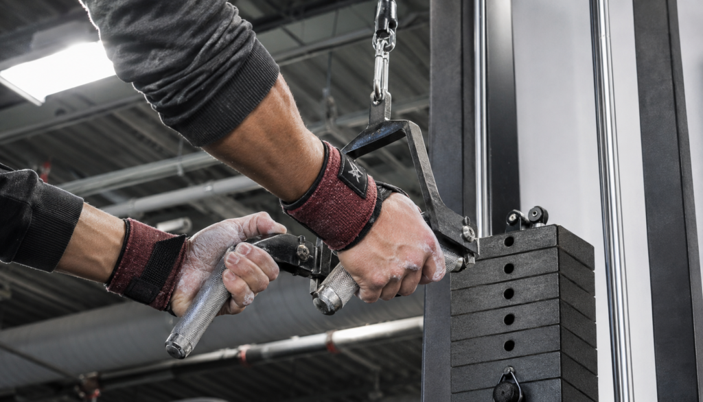 Close crop of chalked hands gripping cable machine handle