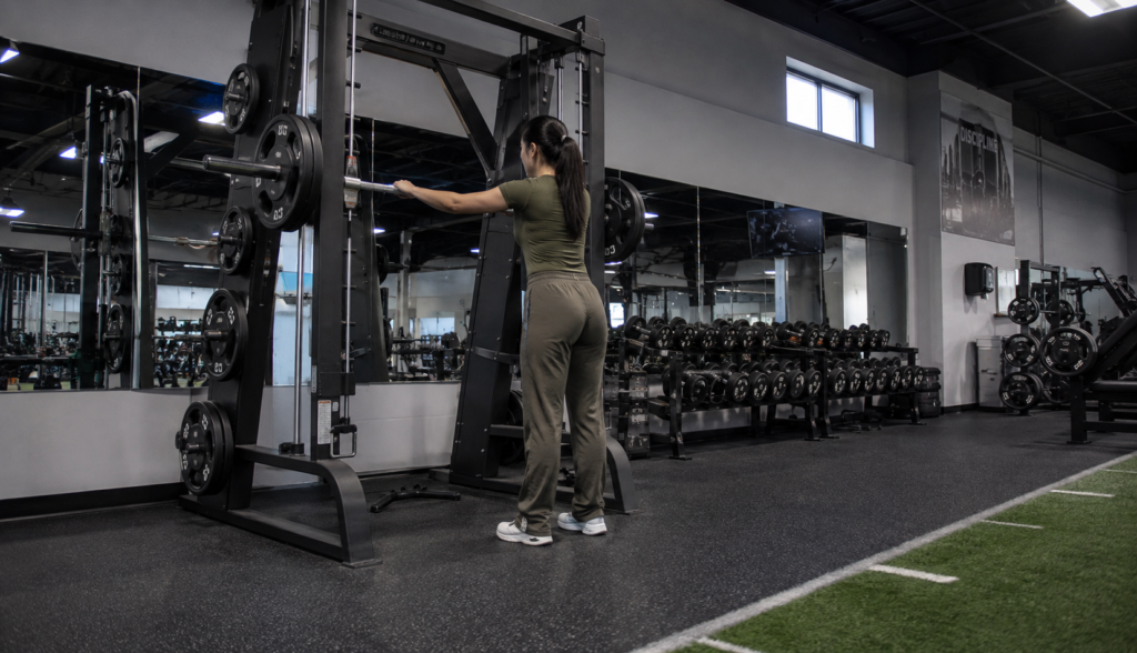 Wide low-angle shot of lifter setting up at Smith machine